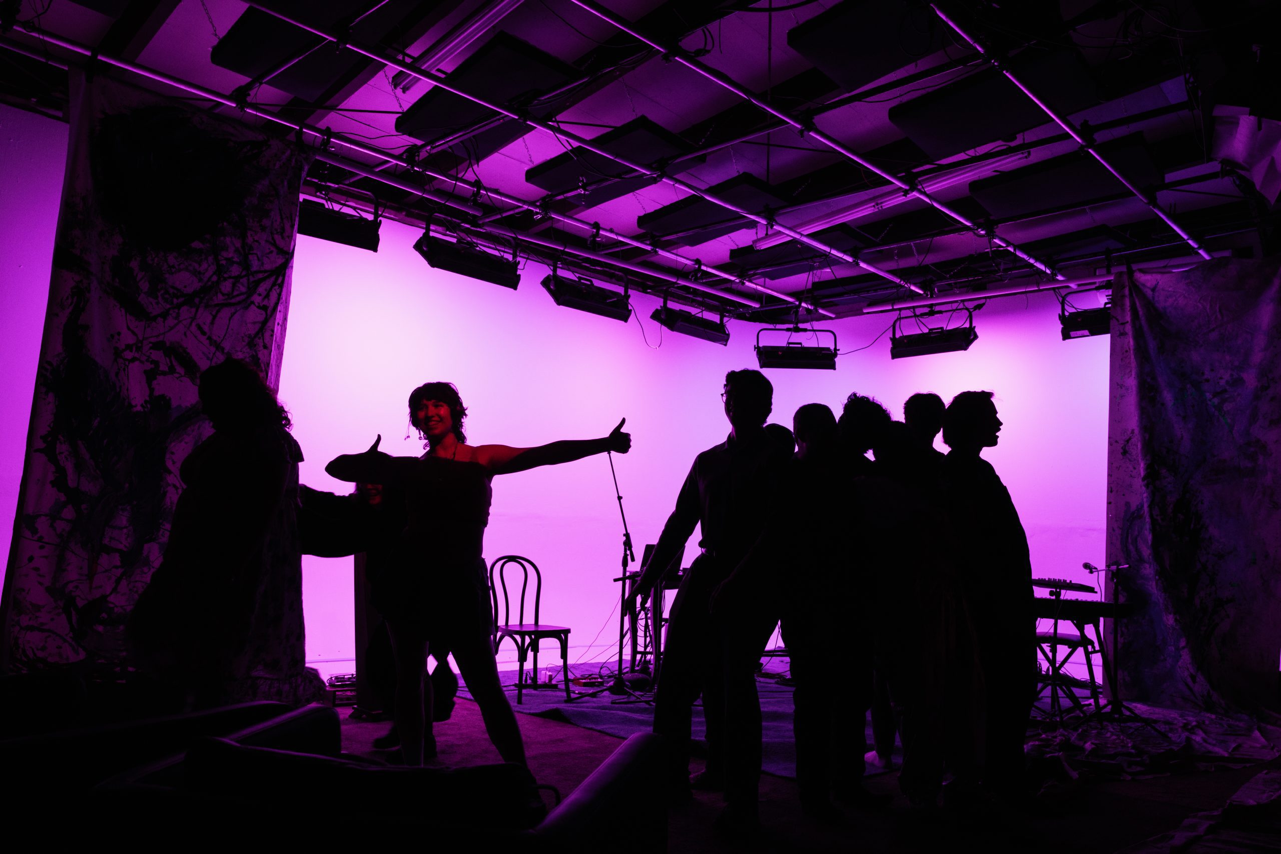 silhourette of group in front of a pink lit stage